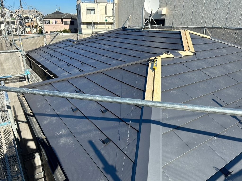 加須市アパート屋根の棟部に棟板金を施工している様子(屋根葺き替え工事)