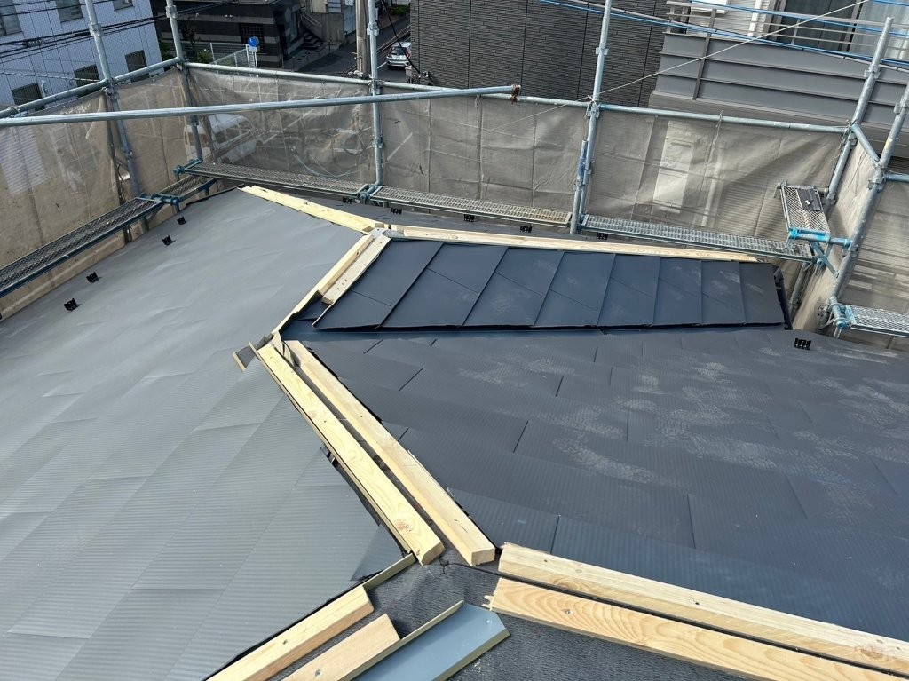 加須市の賃貸アパート屋根で棟板金下地となる貫板を設置している様子