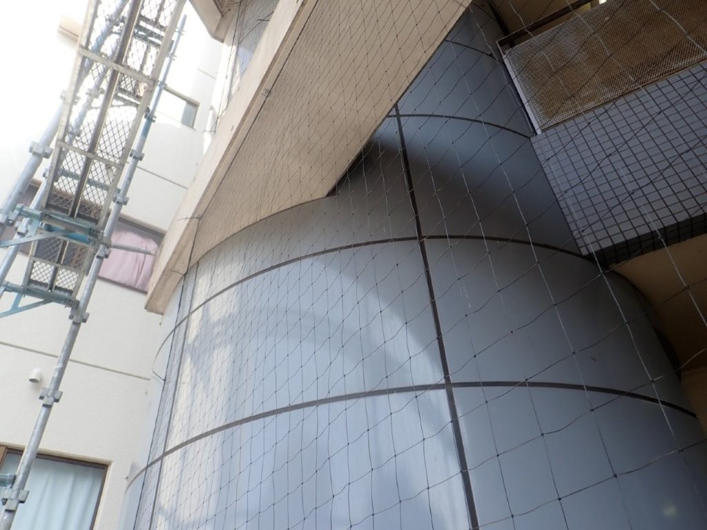 江戸川区マンションの曲面外壁に防鳥ネットを施工した様子